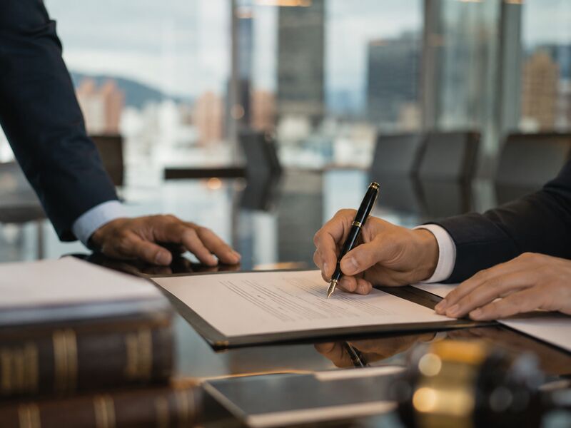 Contract being signed in a Bogotá high-rise conference room